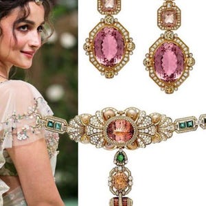 May include: Elegant jewelry set featuring a necklace and matching earrings. The set includes large pink oval gemstones, surrounded by smaller diamonds and set in gold. The earrings have a drop design, and the necklace has a pendant with multiple gemstones.