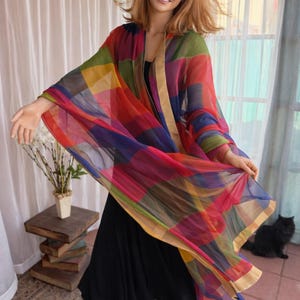 Very long and large multicolors, patchwork, sheer scarf, bordered in gold trim.