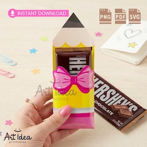 May include: A yellow pencil-shaped gift box with a pink bow, holding a Hershey's chocolate bar. The box has the text "Art Idea printables" and "INSTANT DOWNLOAD". A Hershey's chocolate bar is next to the box.