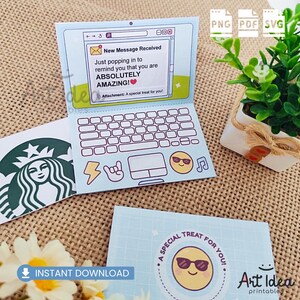 May include: A light blue laptop-shaped greeting card with a keyboard design and the message "New Message Received." The card includes a smiling emoji wearing sunglasses and the text "A special treat for you!" Also visible is a Starbucks logo.