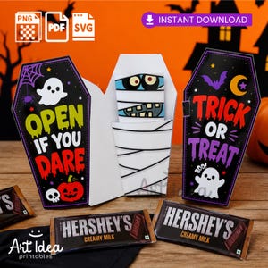 Pode incluir: Um artesanato de papel de Halloween em forma de caixão com uma múmia dentro. O exterior exibe o texto OPEN IF YOU DARE e TRICK OR TREAT com gráficos de fantasmas, abóboras e morcegos. Duas barras de chocolate Hershey's Creamy Milk à frente.