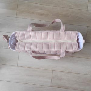 Pode incluir: Uma bolsa tote rosa e branca com padr&atilde;o xadrez, com fecho de correr e duas al&ccedil;as. A bolsa tem um design acolchoado e um detalhe de la&ccedil;o de um lado. O interior &eacute; branco.