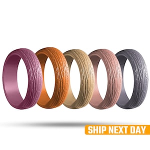 May include: Five silicone rings in various colors: plum, orange, tan, pink, and gray. Each ring has a textured wood grain pattern. The rings are displayed against a white background.