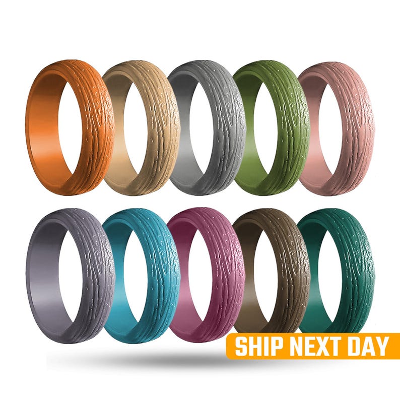 May include: A collection of ten silicone rings in various colors, each with a textured wood grain pattern. Colors include orange, tan, gray, green, pink, purple, teal, burgundy, brown, and teal. The rings are displayed against a white background.