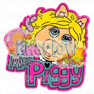 May include: A colourful graphic sticker featuring the character Miss Piggy with bright yellow hair, blue eyeshadow, and long eyelashes. The design includes the text Miss Piggy in bold pink and blue lettering with a small black Mickey Mouse icon.