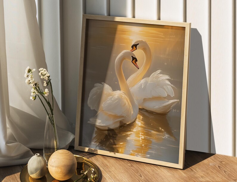 May include: A framed painting depicting two white swans with their necks intertwined, set against a golden sunset backdrop. The swans are in a lake with reflections of the sunset.
