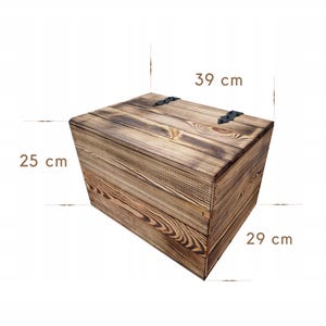 May include: A rustic wooden storage chest, 15.3 inches long, 11.4 inches wide, and 9.8 inches high. The chest is made of wood with a dark brown finish and black metal hinges. The wood grain is visible, adding to the chest's vintage appeal.