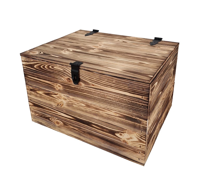 K&ouml;nnte beinhalten: Eine quadratische Holz-Aufbewahrungsbox mit rustikalem, verbranntem Holzfinish. Die Truhe hat einen Klappdeckel mit einem schwarzen Metallverschluss und zwei kleineren Metallscharnieren. Die Holzmaserung ist sichtbar.
