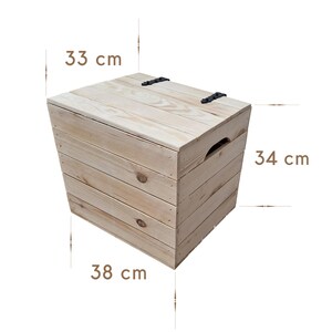 May include: A light-colored wooden storage box with a hinged lid and a handle. The box is 13 inches high, 13.4 inches wide, and 15 inches long. The lid is secured with two black metal hinges.