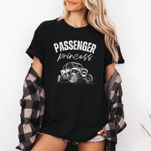 May include: Black t-shirt with white text that reads "Passenger princess" and a graphic of a white off-road vehicle.