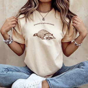 Raccoon T-Shirt Powered by Spite and Snacks Funny Animal Shirt, Trash Panda Meme Tee, Vintage Woodland Creature Aesthetic Top