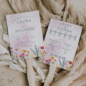 Könnte beinhalten: Zwei Hochzeitsfächer mit floralen Designs und Holzgriffen. Die Fächer zeigen die Namen "Laura und Hudson", das Hochzeitsdatum und einen Zeitplan der Ereignisse. Florale Muster in Rosa, Gelb und Blau schmücken den unteren Bereich.