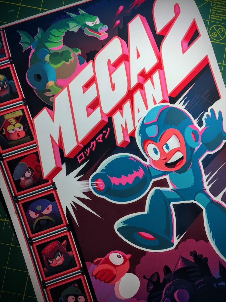 May include: Mega Man 2 poster featuring the character in a blue and red suit, firing a blast. A green dragon and other characters are also shown. The title is in large white letters with a red outline, and Japanese text is included.
