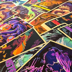Puede incluir: Una colecci&oacute;n de carteles coloridos con ilustraciones de monstruos. Los carteles presentan obras de arte vibrantes con texto que dice "Monster Hunting!" y "Splash Splash!" en un estilo din&aacute;mico y orientado a la acci&oacute;n. La paleta de colores incluye azules, morados, naranjas y verdes.
