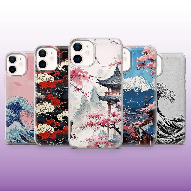 May include: Five different iPhone cases with Japanese-inspired designs. The cases feature images of cherry blossoms, Mount Fuji, a pagoda, and waves. The cases are all clear and show the phone's color through the design.
