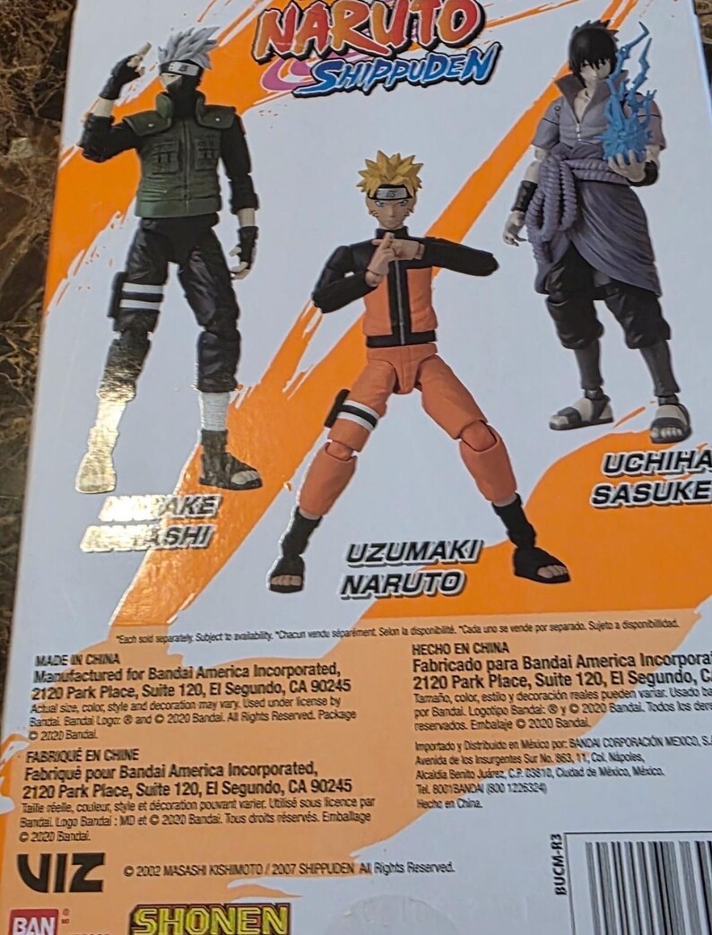 Op de afbeelding: Achterkant van een Naruto Shippuden actiefiguurverpakking met Kakashi, Naruto en Sasuke. De figuren staan in dynamische poses, met heldere kleuren en gedetailleerde ontwerpen. De verpakking bevat tekst en logo's.