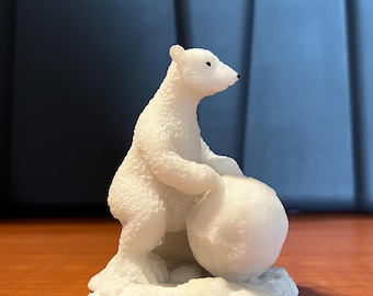 White polar bear pushing a snowball figurine