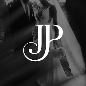 Op de afbeelding: Zwart-wit trouwfoto met een groot wit "JP" monogram. De bruid draagt een witte jurk met een lage halslijn en een sluier. De bruidegom draagt een zwart pak. De afbeelding is monochroom.
