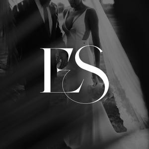 May include: Monochrome image featuring a bride in a white wedding dress with a plunging neckline and a long veil. The image includes the letters "FS" in a stylized font, suggesting a wedding-related brand or logo. A person in a suit is also visible.