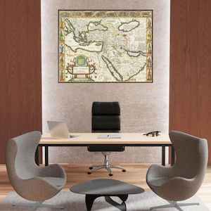 May include: A framed antique map of The Turkish Empire, featuring detailed cartography in shades of beige, green, and brown. The map is displayed above a modern office desk with a laptop, chair, and two gray egg-shaped chairs.