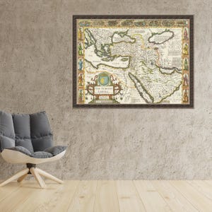 May include: A framed vintage map of the Turkish Empire, featuring detailed cartography with a brown wooden frame. The map displays geographical features and text, including "The Turkish Empire". The artwork is displayed on a concrete wall.