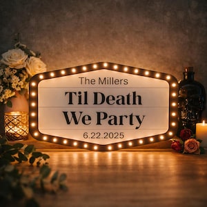 May include: A hexagonal marquee sign with a white face and black border featuring small warm white LED lights. The text reads The Millers, Til Death We Party, and 6.22.2025 in a bold black sans-serif font. The sign has a clean, modern aesthetic.