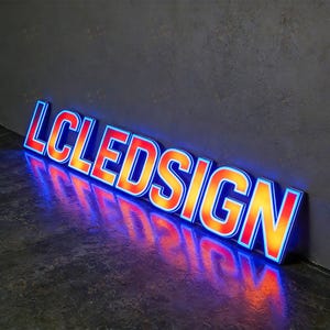 May include: Angled LED sign with the text "LCLEDSIGN". The sign has a red and orange gradient with a blue outline, casting a vibrant reflection on the dark surface. The sign is illuminated, creating a modern aesthetic.