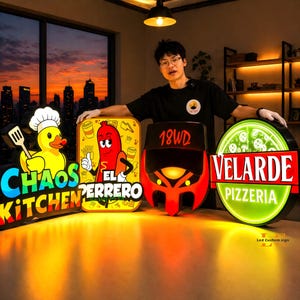 May include: A collection of illuminated LED signs for restaurants. The signs include "Chaos Kitchen" with a duck chef, "El Ferrero" with a cartoon hot dog, "18WD" in red, and "Velarde Pizzeria" with a pizza graphic.