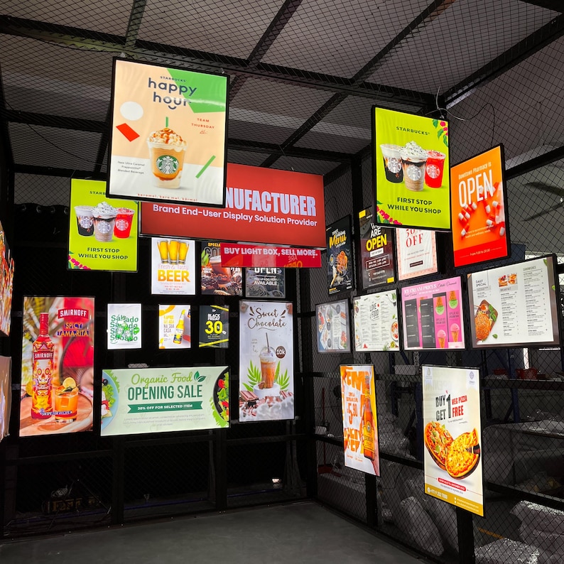 May include: A display of illuminated signs advertising various food and beverage options. Signs include "Happy Hour" for Starbucks, "Beer", "Sweet Chocolate", and "Organic Food Opening Sale". The signs are mounted on a black metal grid.