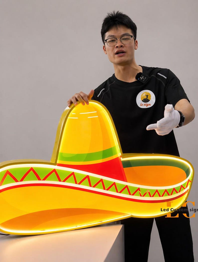 May include: A large, illuminated sombrero sign with a bright yellow brim, a red and green band, and a yellow crown. The sign has the text "Led Custom sign" in the bottom right corner.
