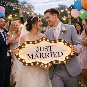 May include: A decorative marquee sign with a scalloped black frame and warm white LED bulbs, featuring the text "JUST MARRIED" in bold black lettering. The sign is held horizontally, showcasing a vintage-inspired design with glowing lights.