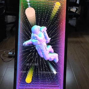 May include: A rectangular infinity mirror featuring a central white astronaut figure floating against a deep black background with a multi-colored rainbow light border. The design includes yellow planet icons and white star shapes, with the text MADE IN CHINA.