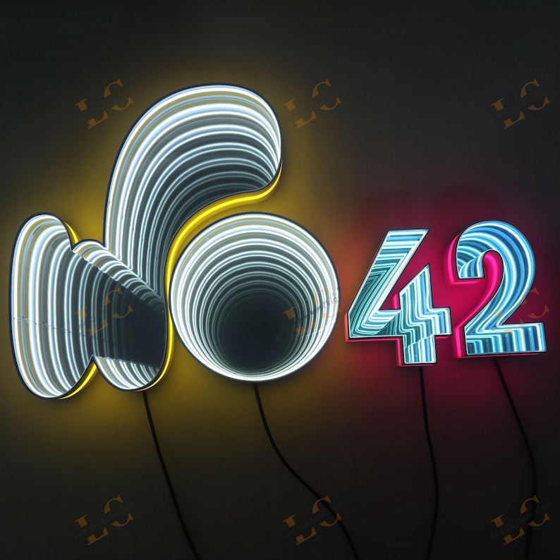 May include: Illuminated neon sign featuring the word "no" and the number "42". The "no" is a stylized design with yellow and white neon lights. The "42" is in blue and pink neon lights, with black wires.