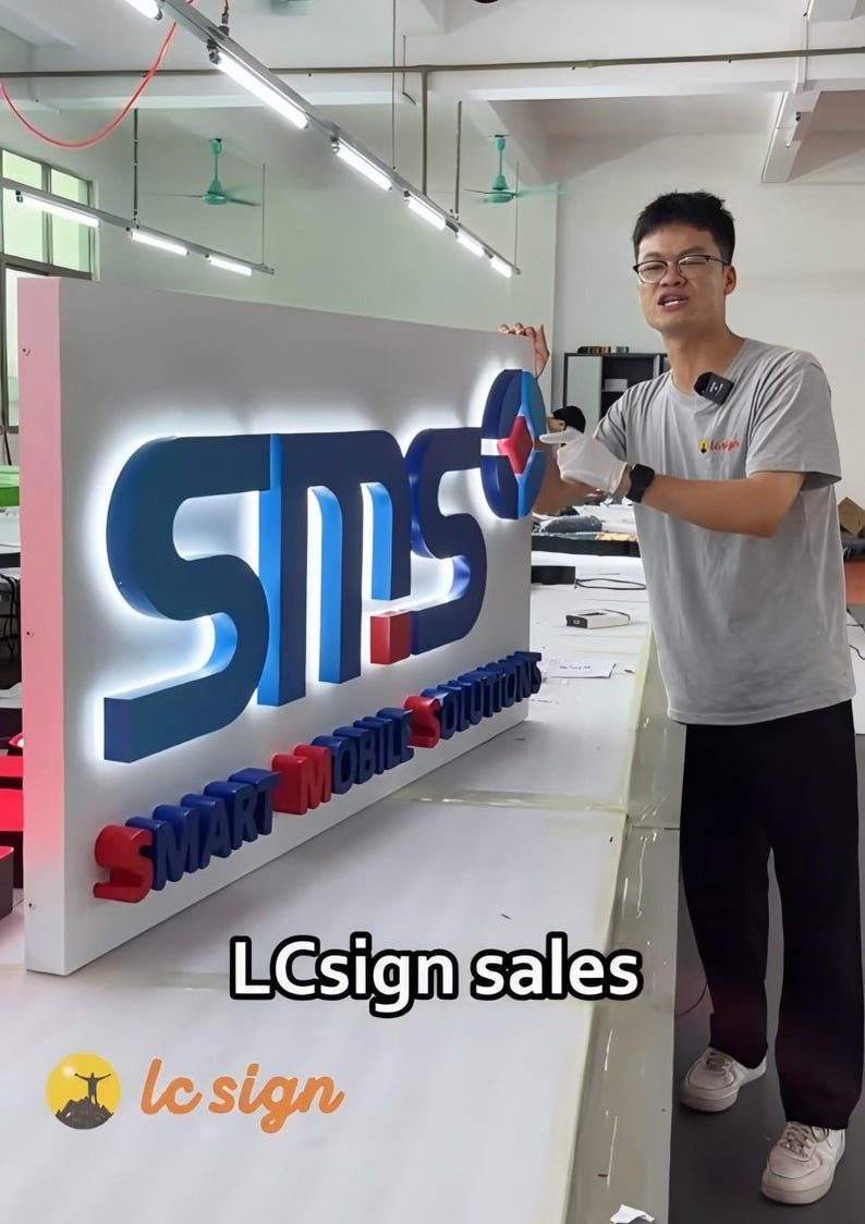 Illuminated custom logo channel letters for business signage, bright LED storefront sign installed on building exterior wall.