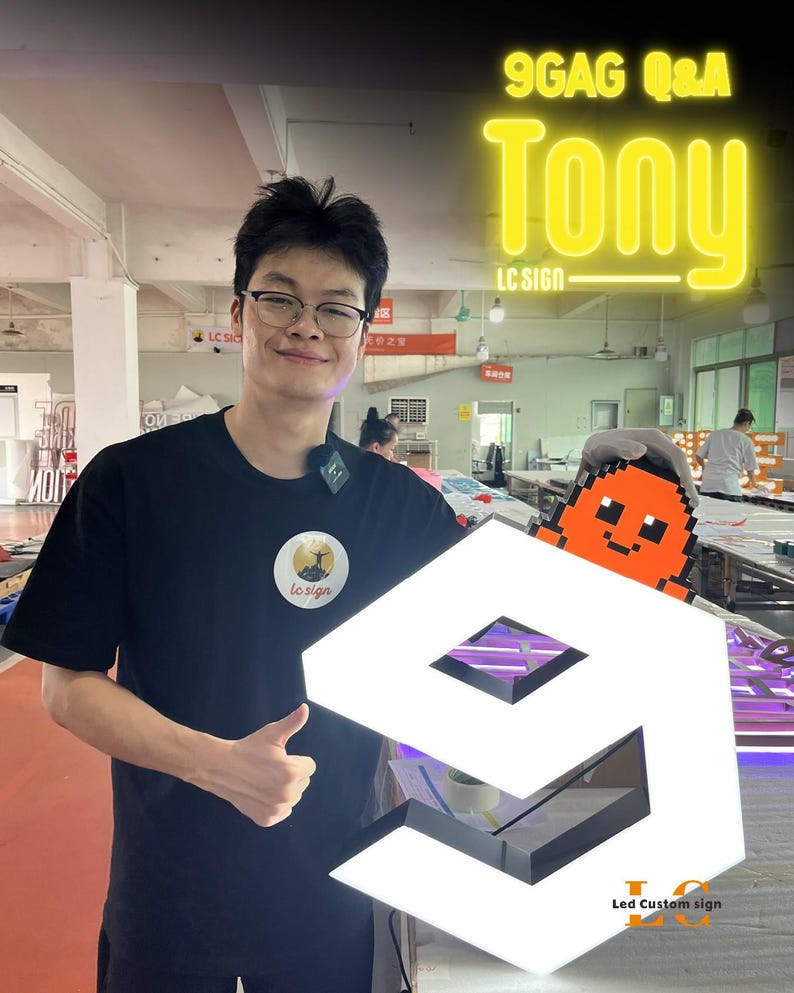 May include: A custom LED sign shaped like the number nine with a white illuminated surface and black edges. An orange pixelated character is attached to the top right corner. The sign features the text 9GAG Q&A Tony LC SIGN in yellow.