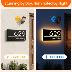 May include: A rectangular black house address sign featuring the white text 629 and Hero Way, shown in two states: unlit during the day and illuminated with a warm glow at night. The sign includes a horizontal white line separating the numbers and text.