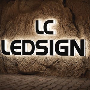 May include: A wall-mounted sign featuring the black letters LC and LEDSIGN with a white backlit glow. The sign is mounted against a textured, light brown stone surface, creating a high-contrast display with illuminated edges behind each letter.