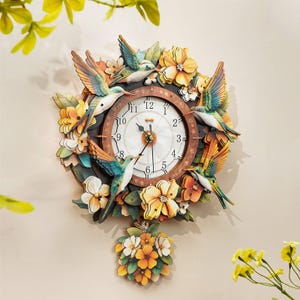 May include: A round wall clock featuring a white face with black numerals, surrounded by a decorative frame of colourful hummingbirds and yellow flowers. A floral pendulum hangs from the bottom, with three black clock hands at the centre.