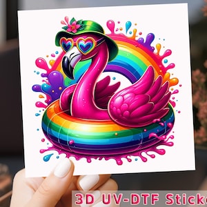 May include: A vibrant sticker featuring a cartoon flamingo wearing heart-shaped sunglasses and a green hat, floating in a rainbow-colored inner tube. A rainbow arches behind the flamingo, with colorful paint splatters. The text "3D UV-DTF Sticker" is at the bottom.