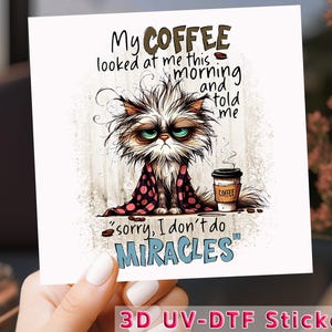 May include: A white cat with messy fur and a pink polka dot robe holds a cup of coffee. The text reads "My coffee looked at me this morning and told me "sorry, I don't do miracles"."  The image is a 3D UV-DTF sticker.
