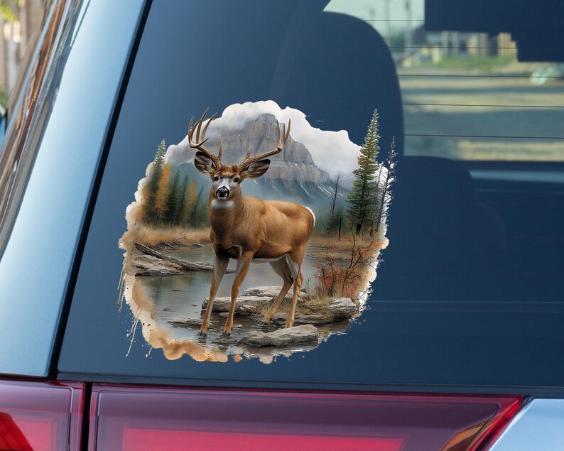 May include: A brown and white deer with large antlers stands in a forest setting. The deer is looking directly at the viewer. The background is a watercolor-style painting of trees, mountains, and a river.