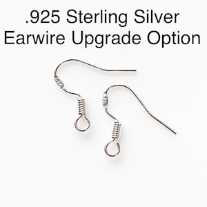 May include: Two silver ear wires with a spring closure. The ear wires are marked with .925, indicating they are made of sterling silver.