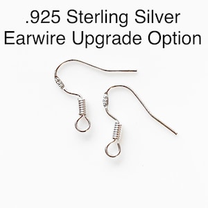 May include: Two silver ear wires with a spring closure. The ear wires are marked with .925, indicating they are made of sterling silver.