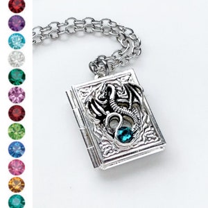 May include: Silver locket necklace with a dragon design and a blue crystal. The locket opens to reveal a small compartment.