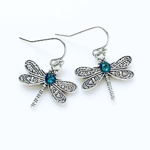May include: Silver dragonfly earrings with teal blue crystal accents.