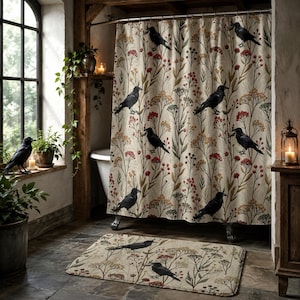 May include: A beige shower curtain and matching bath mat feature a repeating pattern of black crows and botanical elements in red, yellow, and green. The bathroom has a rustic, vintage aesthetic with a window and plants.