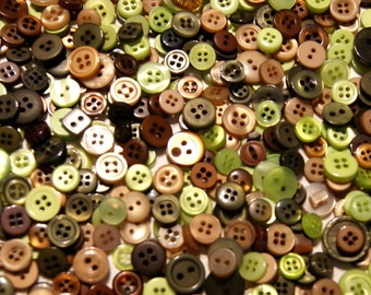 May include: A selection of buttons in various sizes and shades of green, brown, and beige. The buttons have two or four holes, with some featuring a shank. The collection includes both matt and glossy finishes, creating a textured appearance.