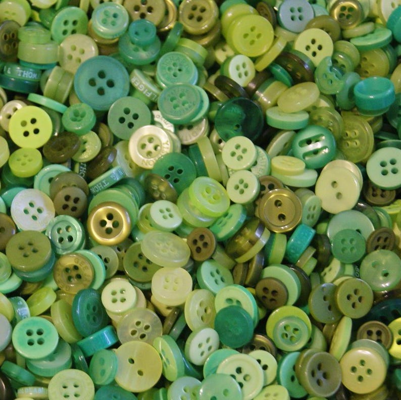 Puede incluir: Una colecci&oacute;n de botones verdes de varios tonos y tama&ntilde;os. Los botones tienen dos o cuatro agujeros, y algunos tienen un v&aacute;stago. Los colores van desde el verde lima claro hasta el verde oliva oscuro.