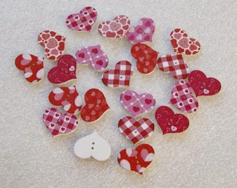 May include: A collection of 17 wooden heart-shaped buttons with various red and pink patterns. The buttons have a white background with red and pink gingham, hearts, and keys.