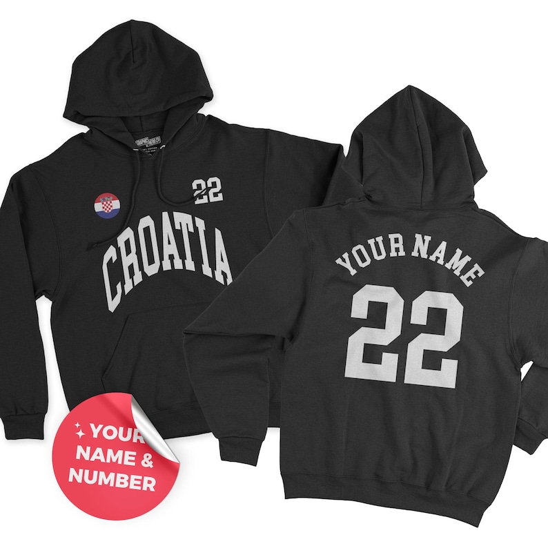 Puede incluir: Sudadera con capucha negra con la palabra "CROATIA" en letras blancas arqueadas, un pin de la bandera croata y el n&uacute;mero "22". La parte trasera de la sudadera con capucha presenta "YOUR NAME" y el n&uacute;mero "22" en blanco.